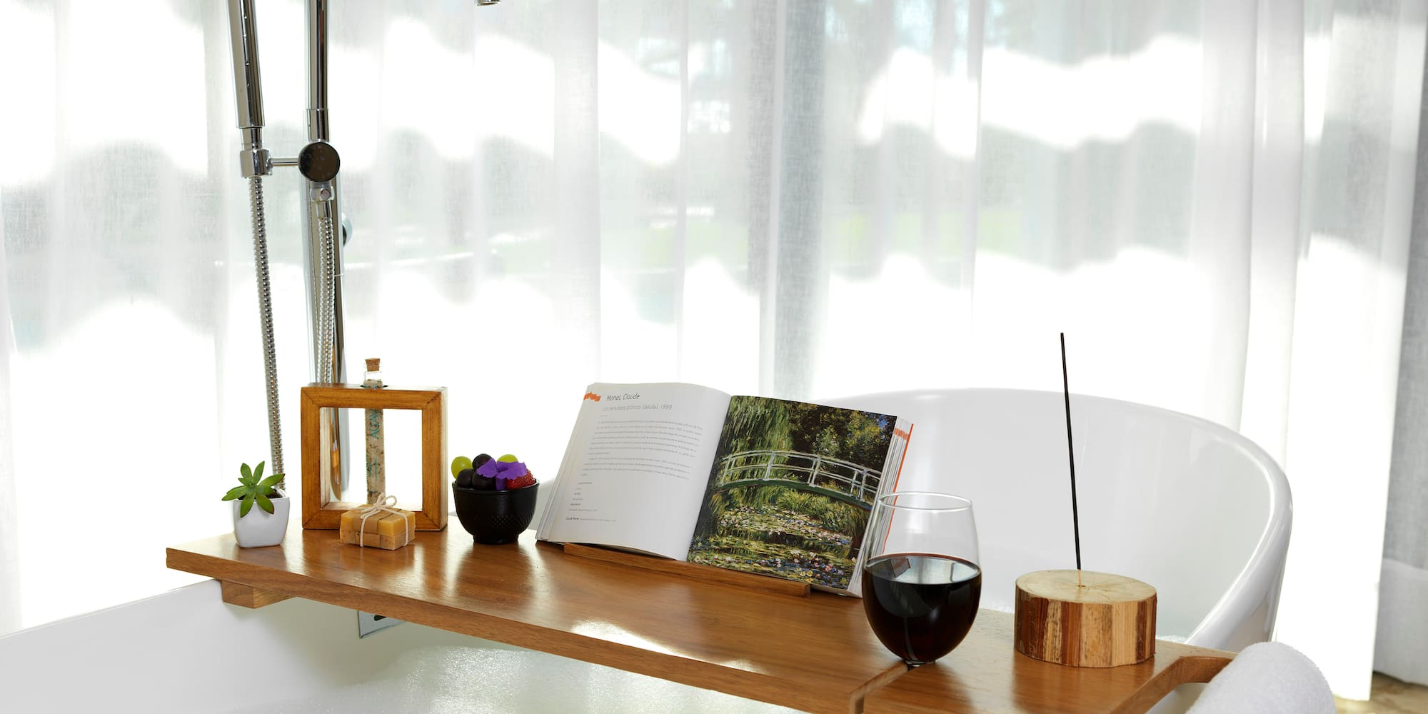 a bathtub with a book and wine on it