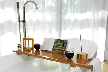 a bathtub with a book and wine on it