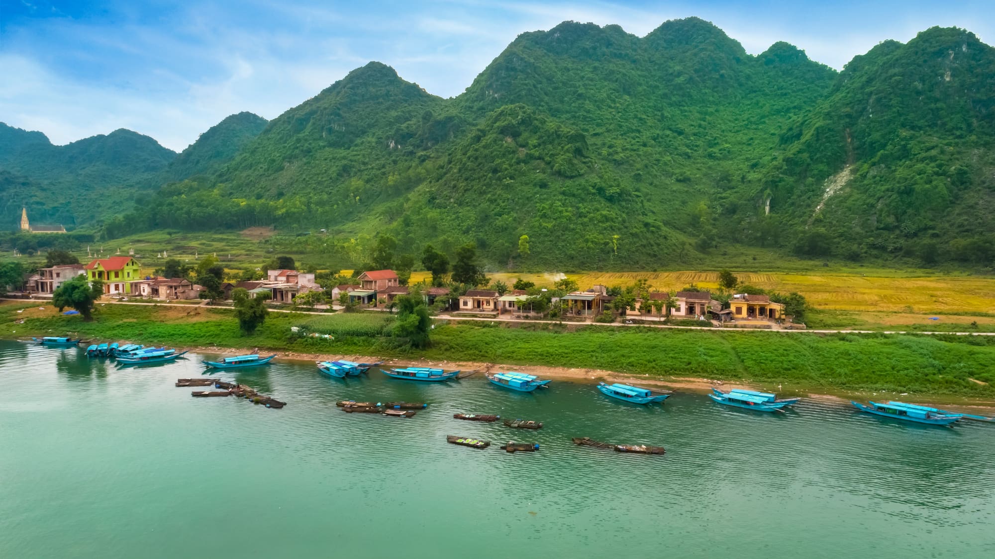 boats on the water next to a village