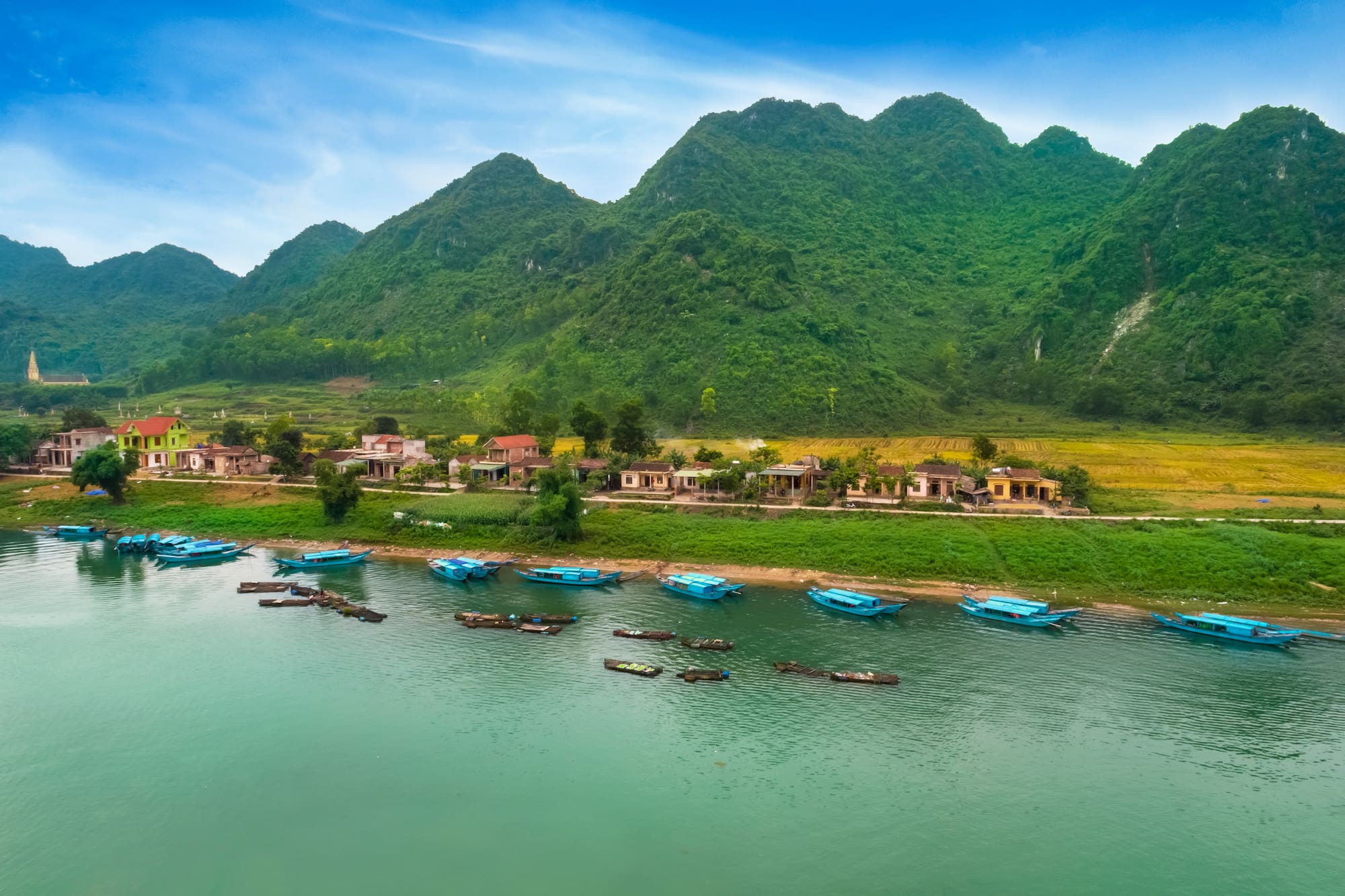 boats on the water next to a village
