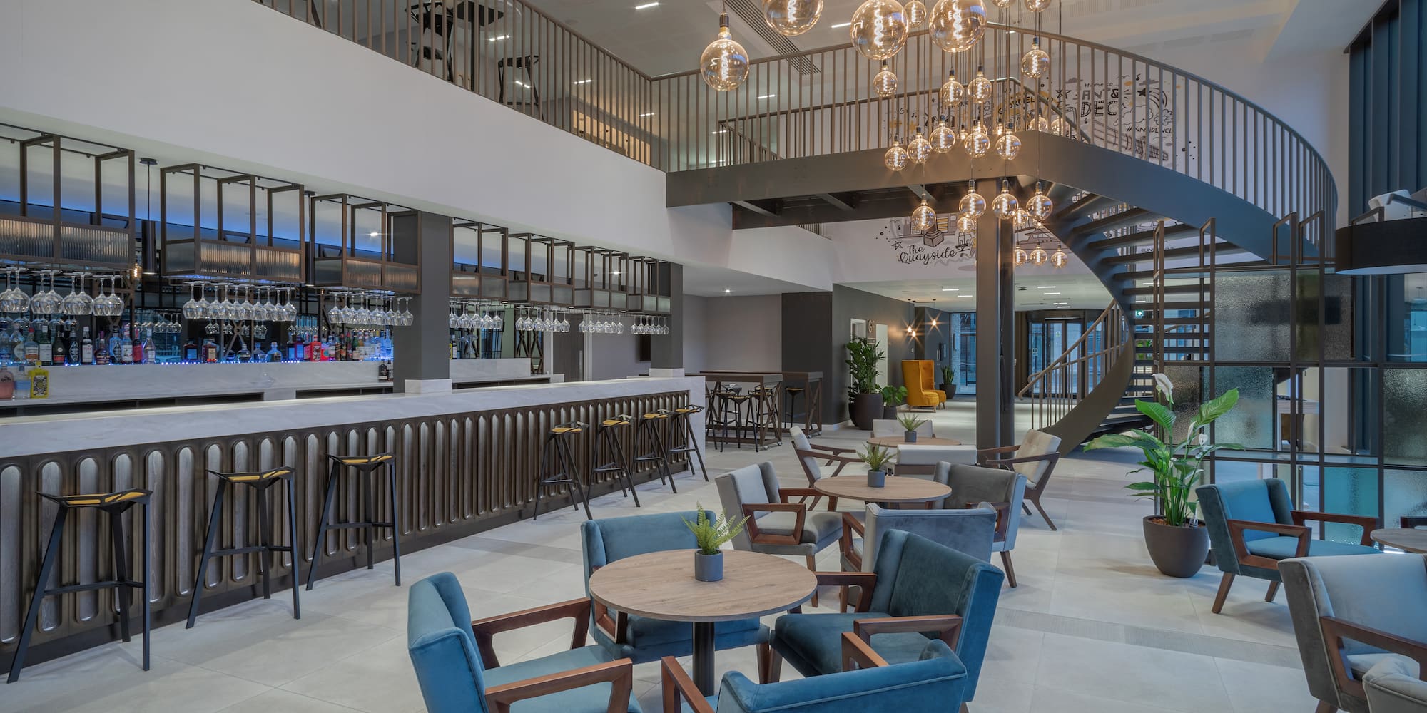 a room with a spiral staircase and tables and chairs