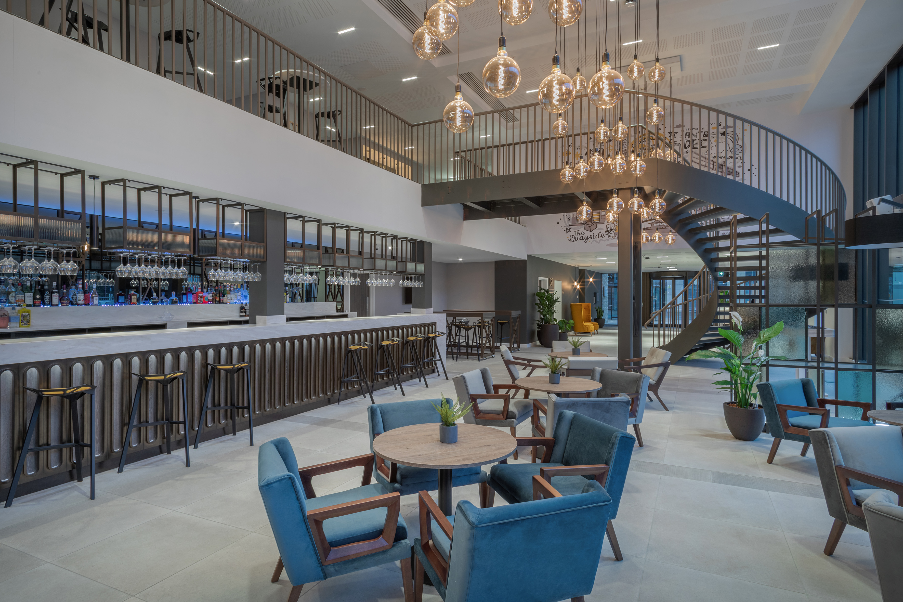 a room with a spiral staircase and tables and chairs