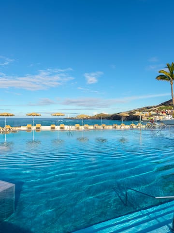 a pool with chairs and umbrellas on the side