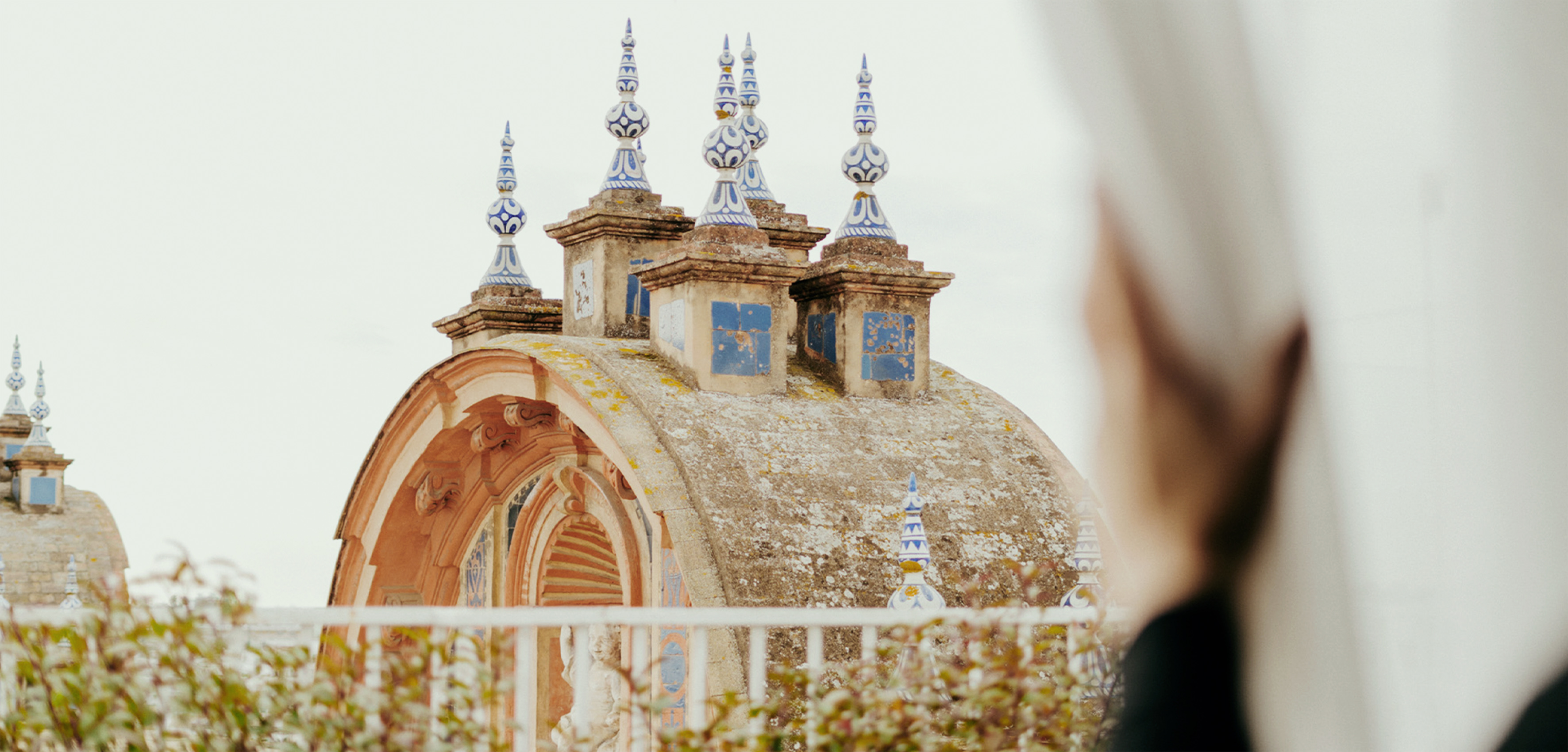 Ornate rooftop with blue and white ceramic spires, weathered dome, and arch.