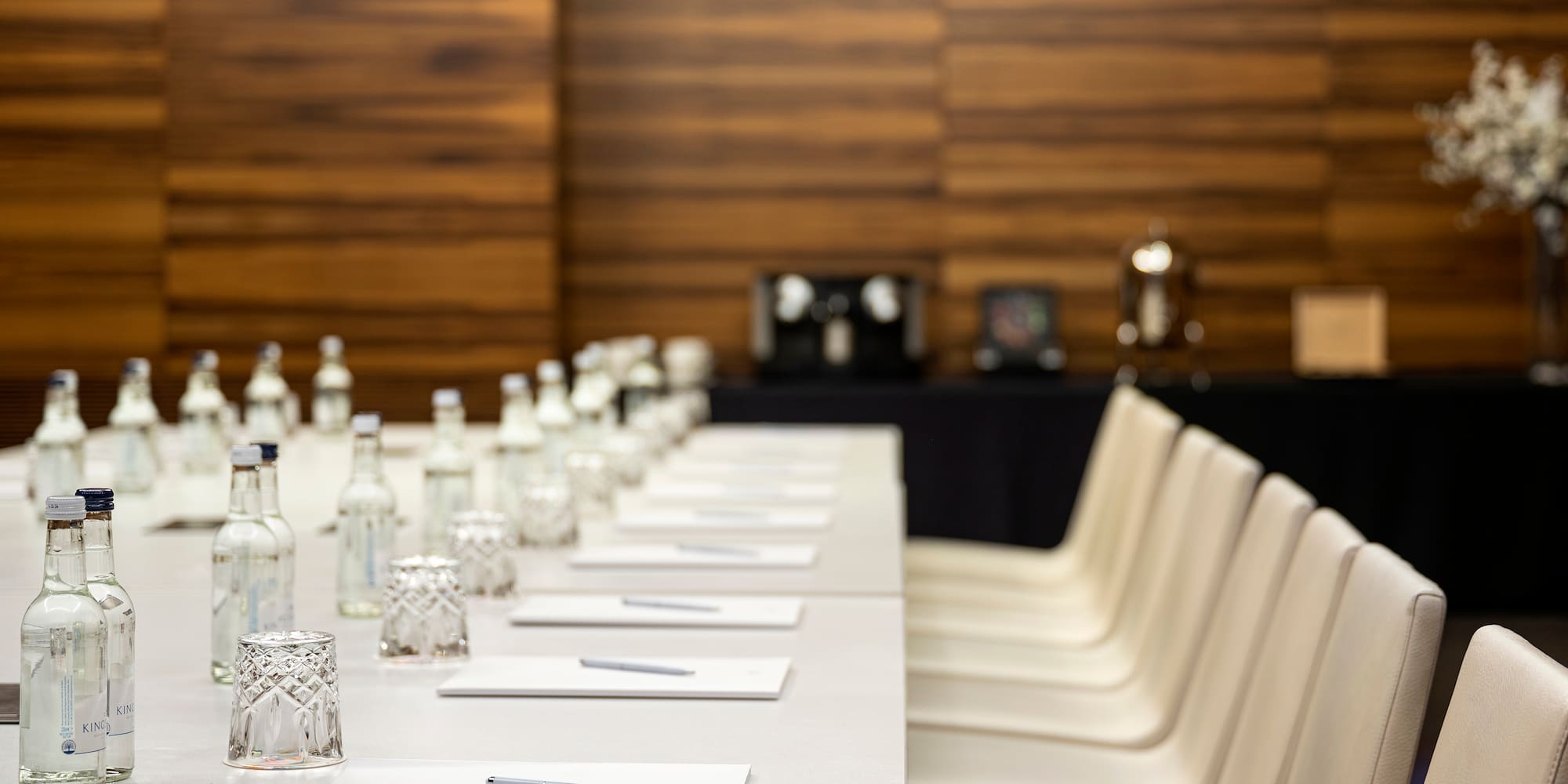 a table with white chairs and a pen and glasses on it