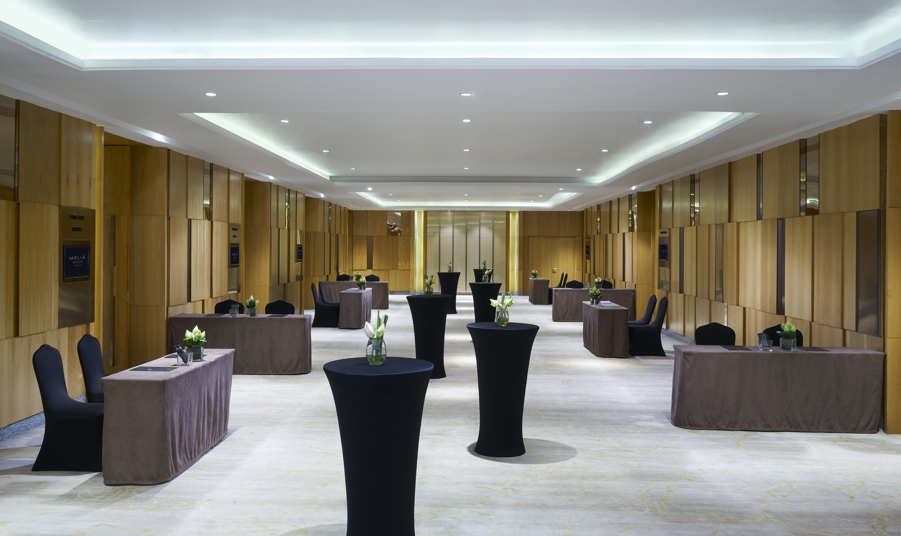 Melia hotel pre-function room with draped tables and tall cocktail tables.