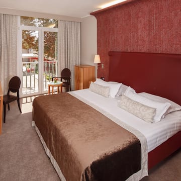 a bed with a red headboard and a table and chairs