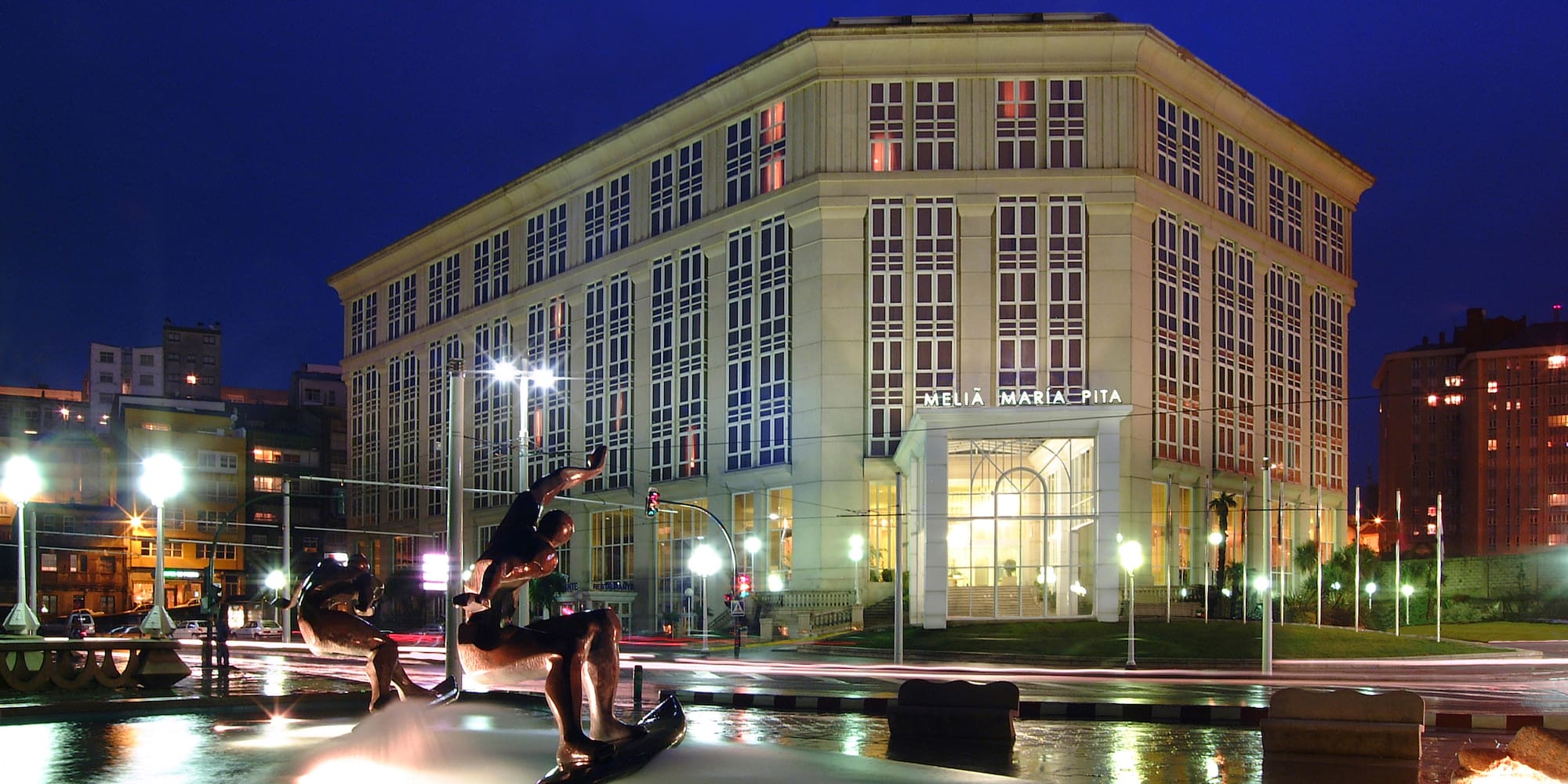 a statue of a surfer in a fountain in front of a building