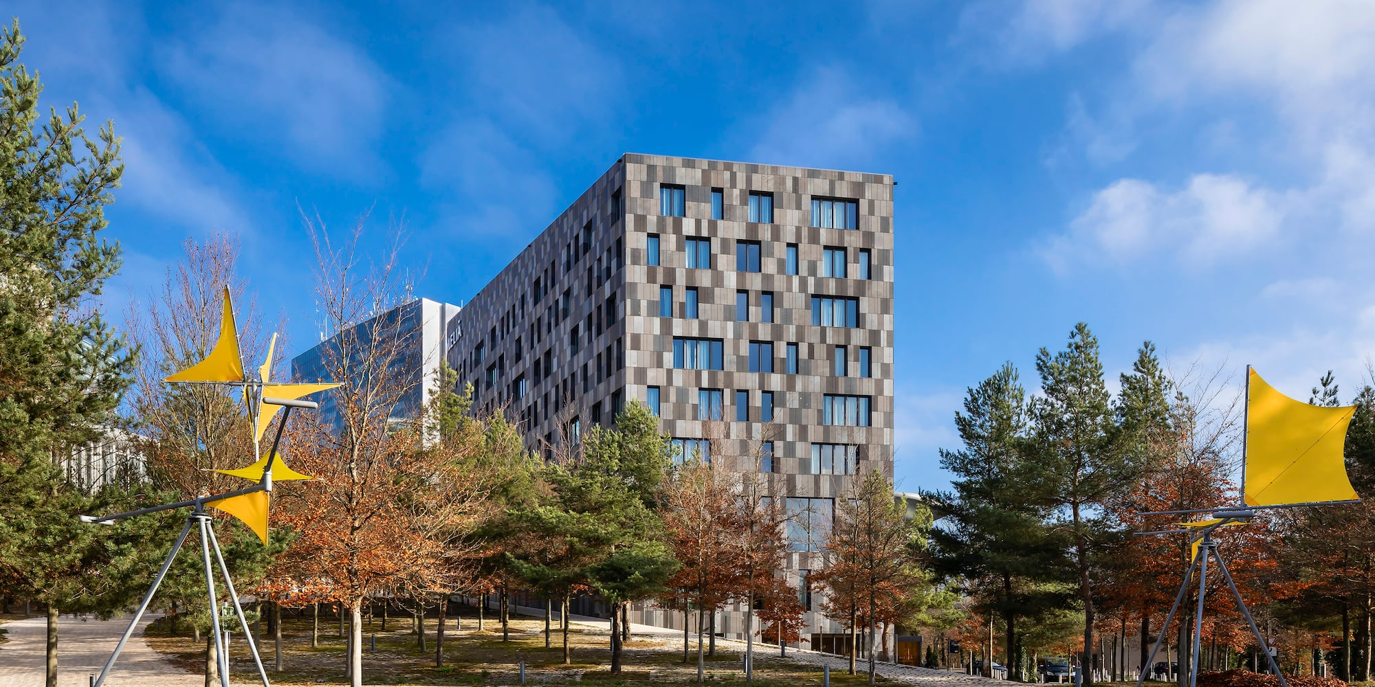 a building with trees and a yellow flag