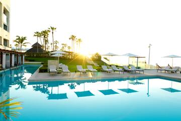 a pool with lounge chairs and umbrellas