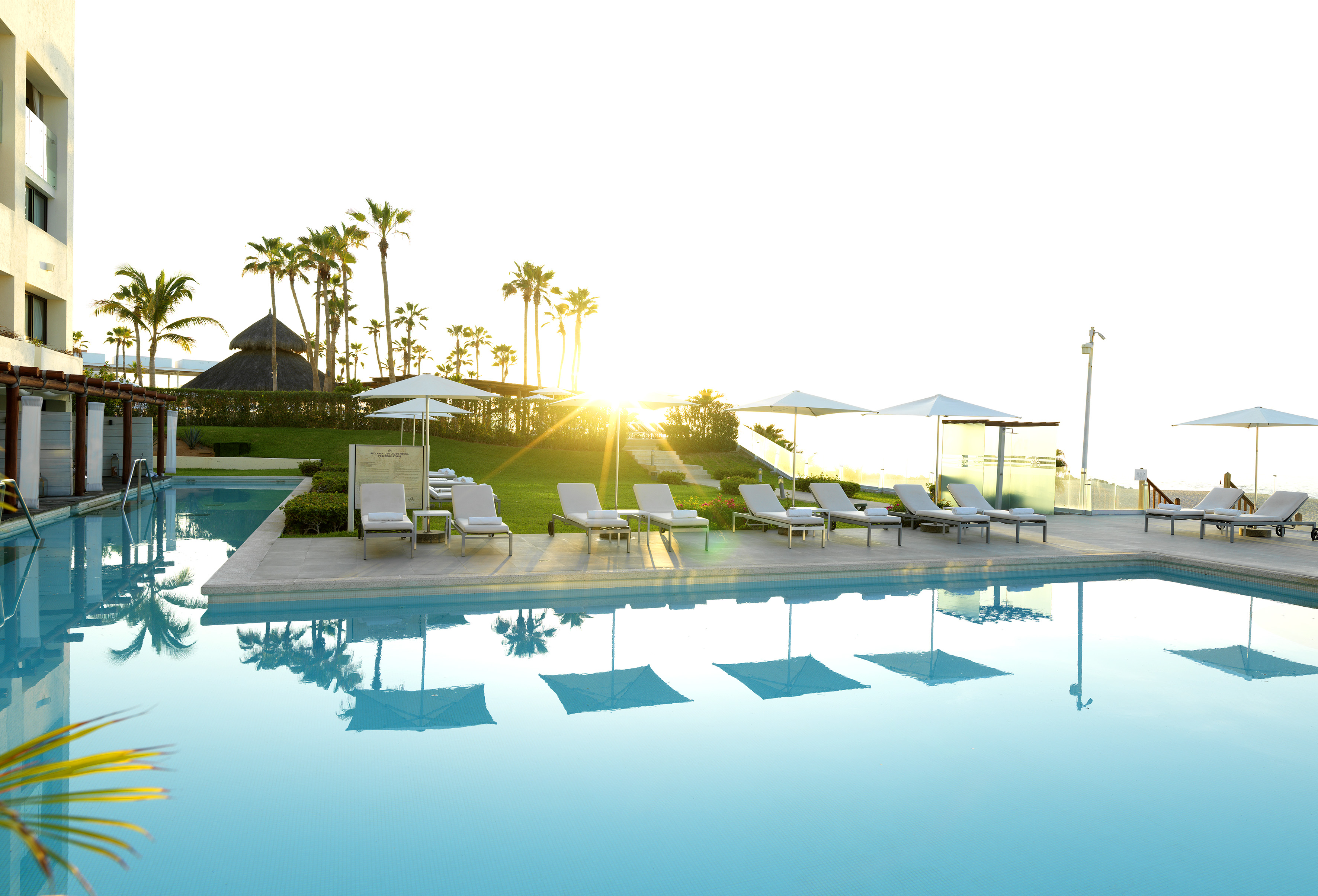 a pool with lounge chairs and umbrellas