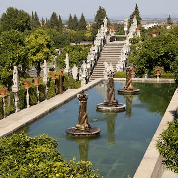 a water fountain with statues in the middle of a garden
