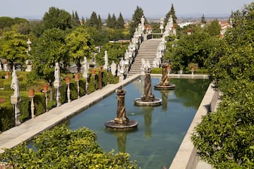 a water fountain with statues in the middle of a garden
