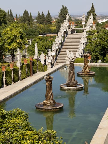 a water fountain with statues in the middle of a garden