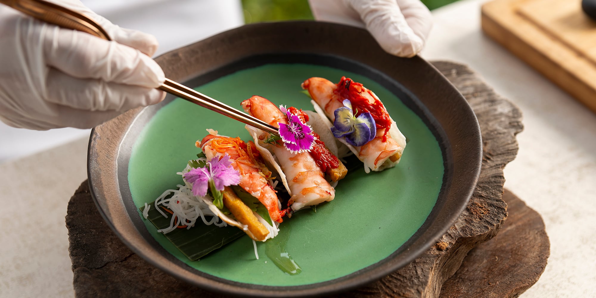 a person holding chopsticks over food