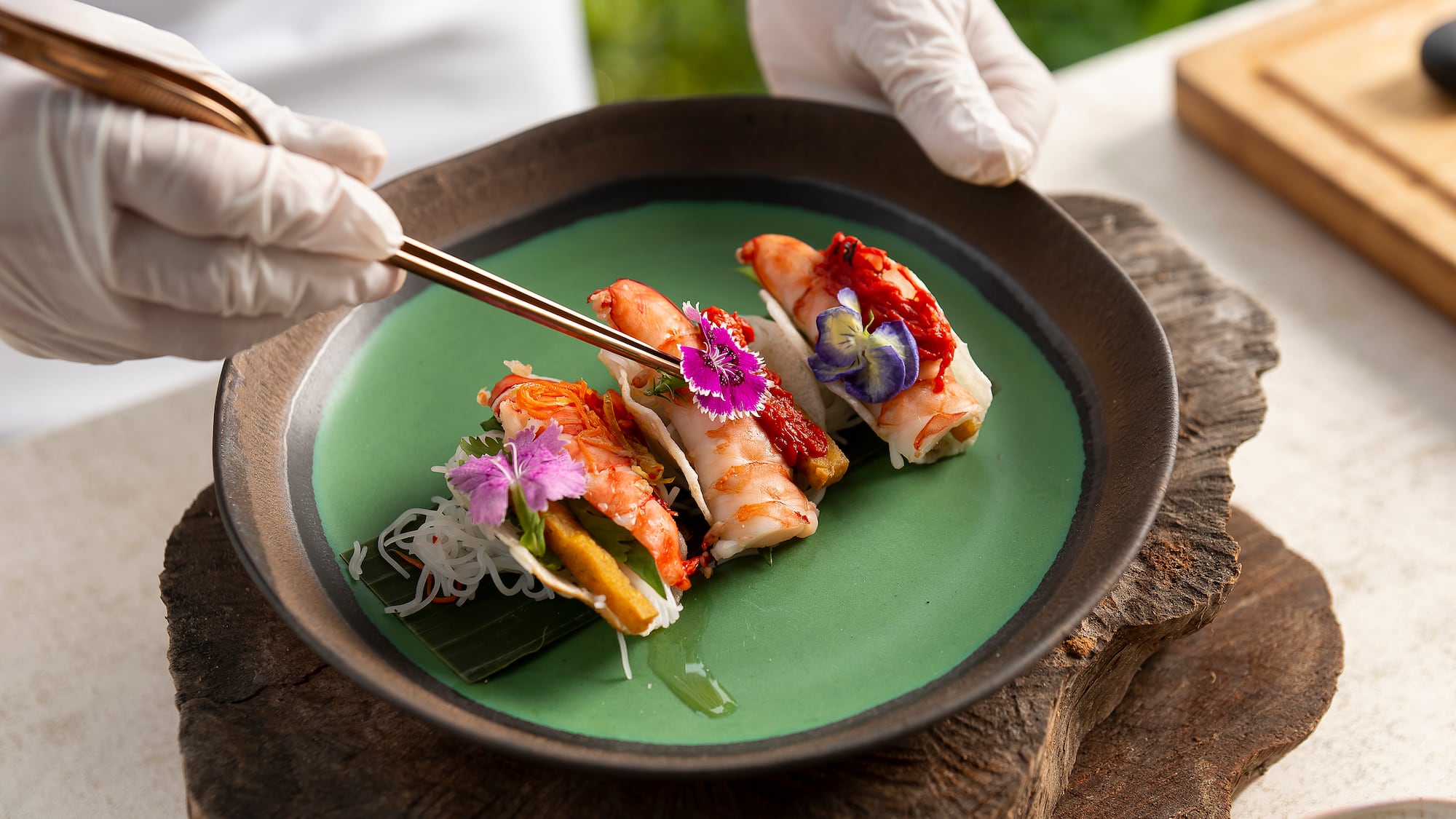 a person holding chopsticks over food