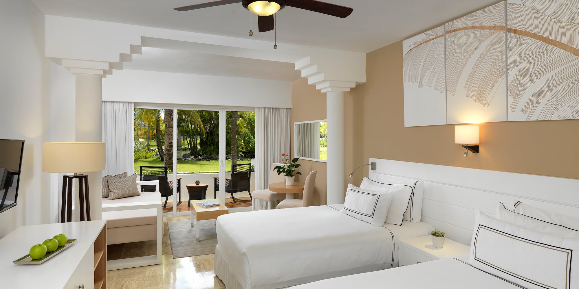 a room with two beds and a ceiling fan