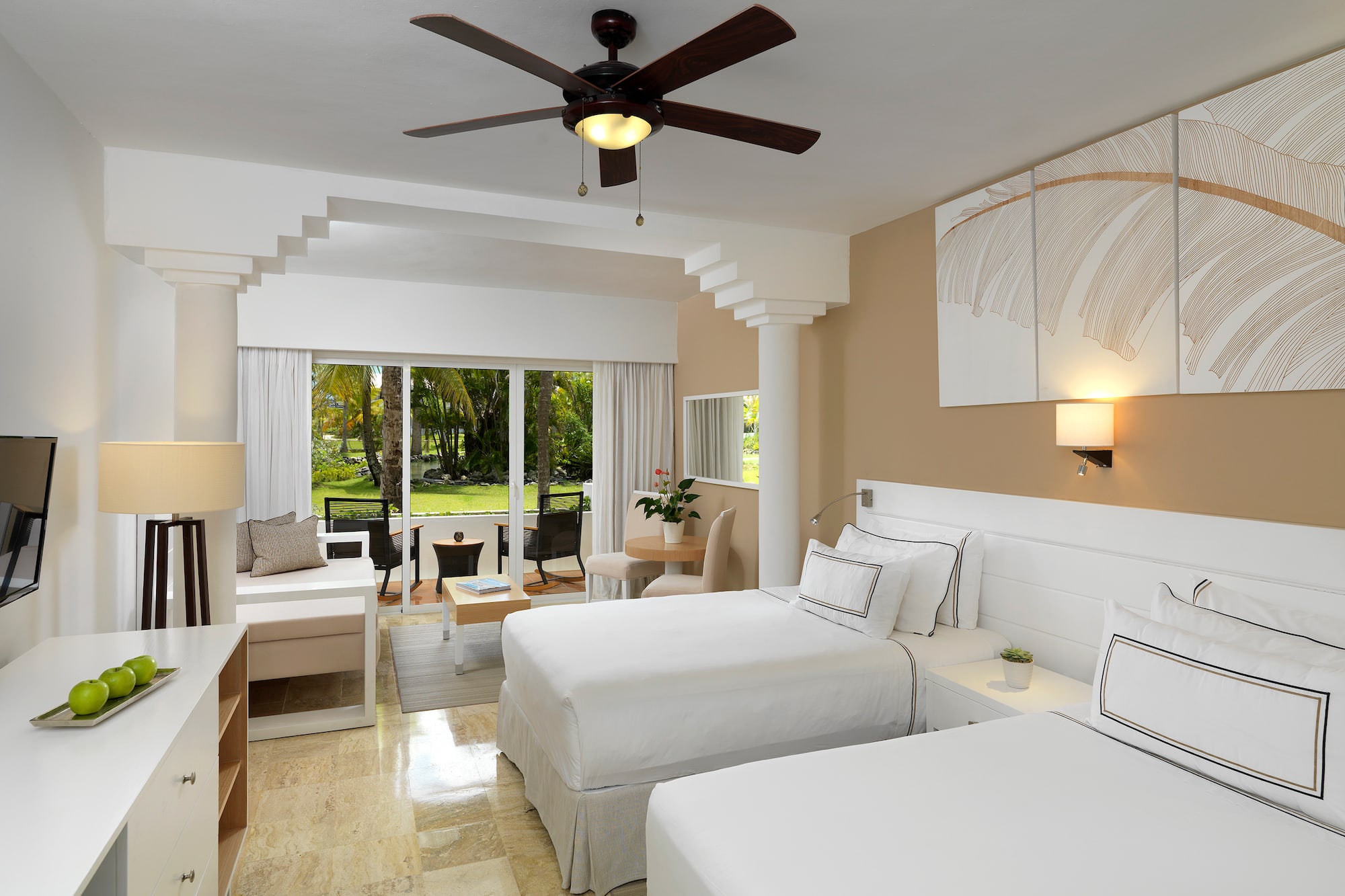 a room with two beds and a ceiling fan