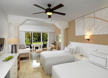a room with two beds and a ceiling fan