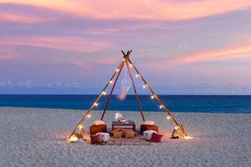 a tent on a beach with lights and a dream catcher