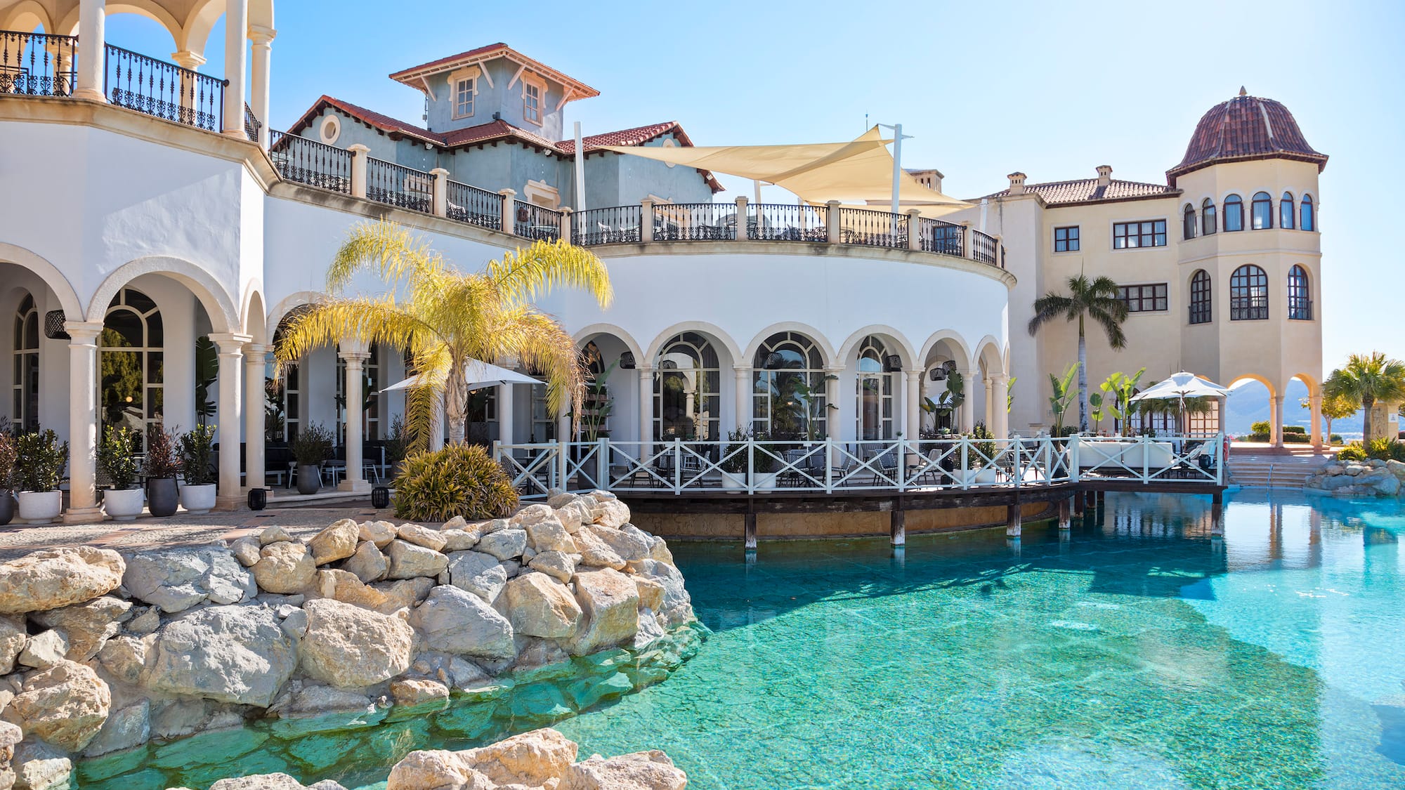 a pool with a building and palm trees