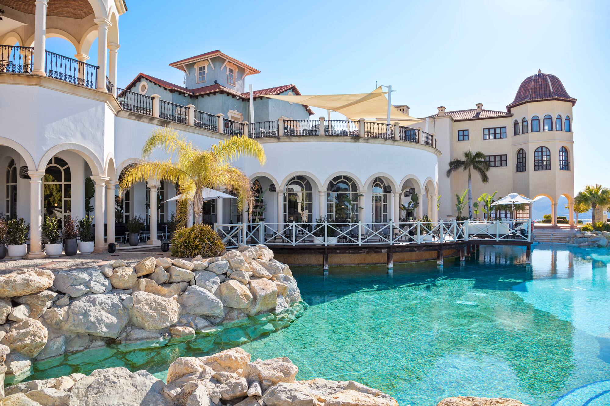 Mediterranean resort with arcaded outdoor dining terrace and turquoise pool.