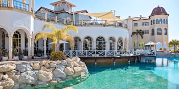 a pool with a building and palm trees