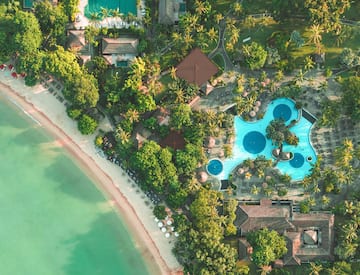 an aerial view of a resort with swimming pools and trees
