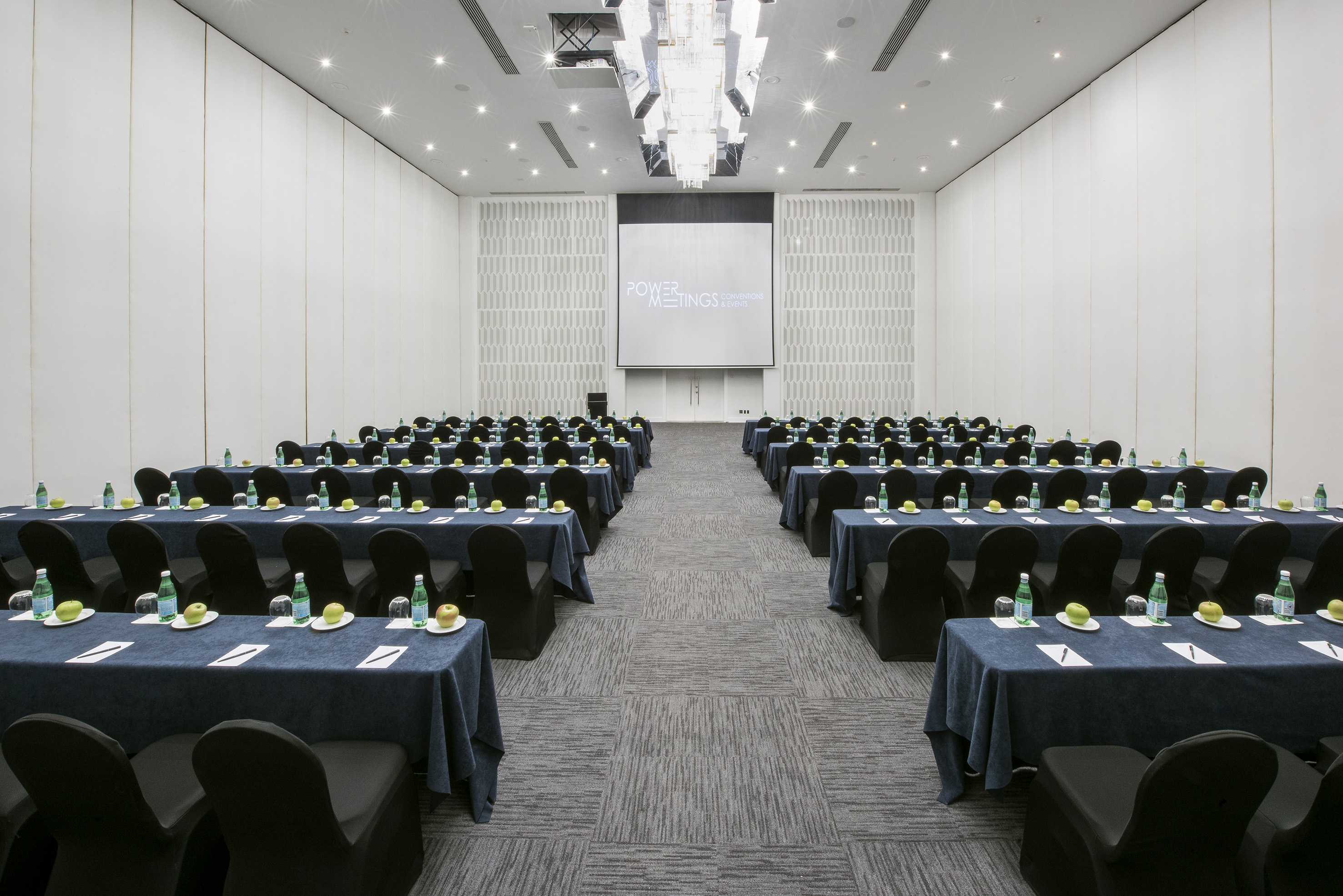 Corporate meeting and event room with classroom setup, projection screen.