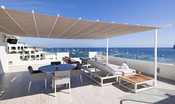 a patio with a large white canopy over a large body of water