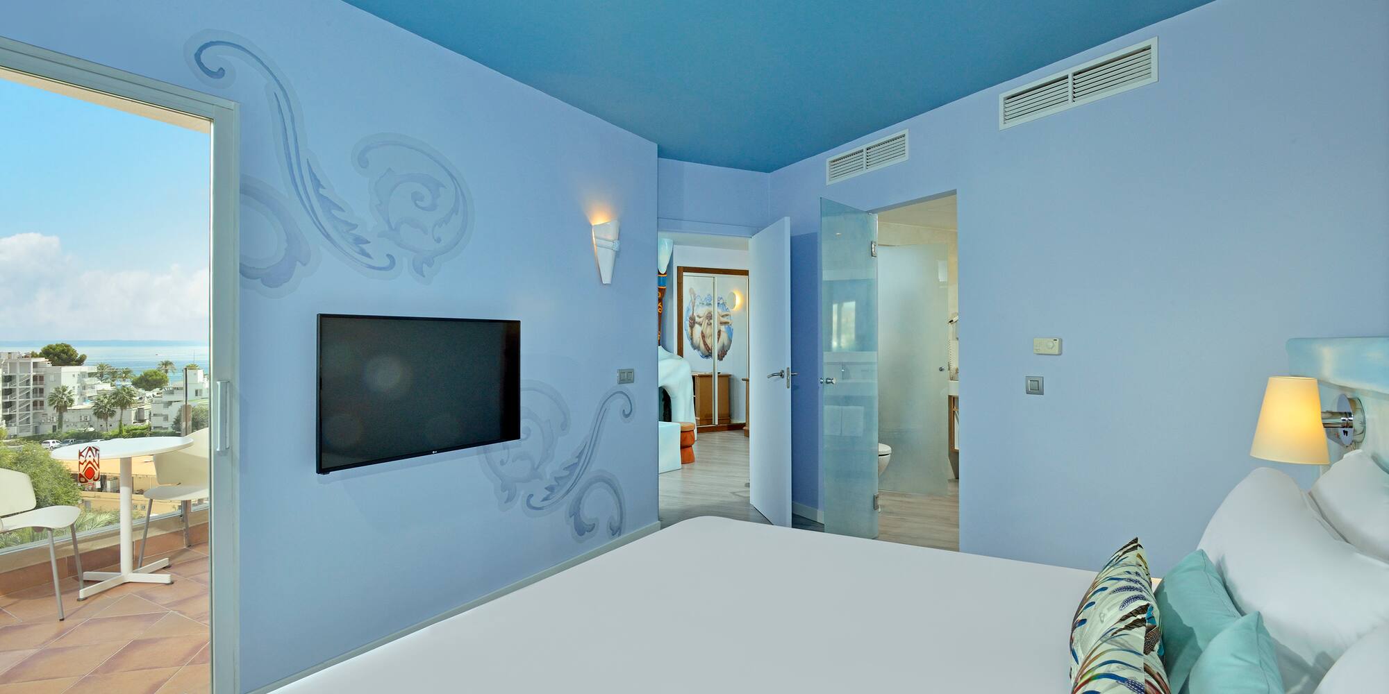 a bedroom with a bed and a television on the wall