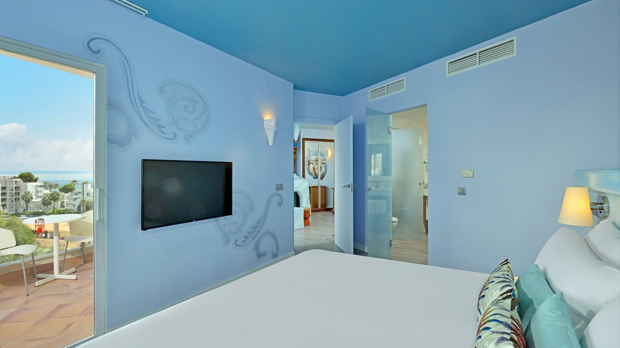 a bedroom with a bed and a television on the wall