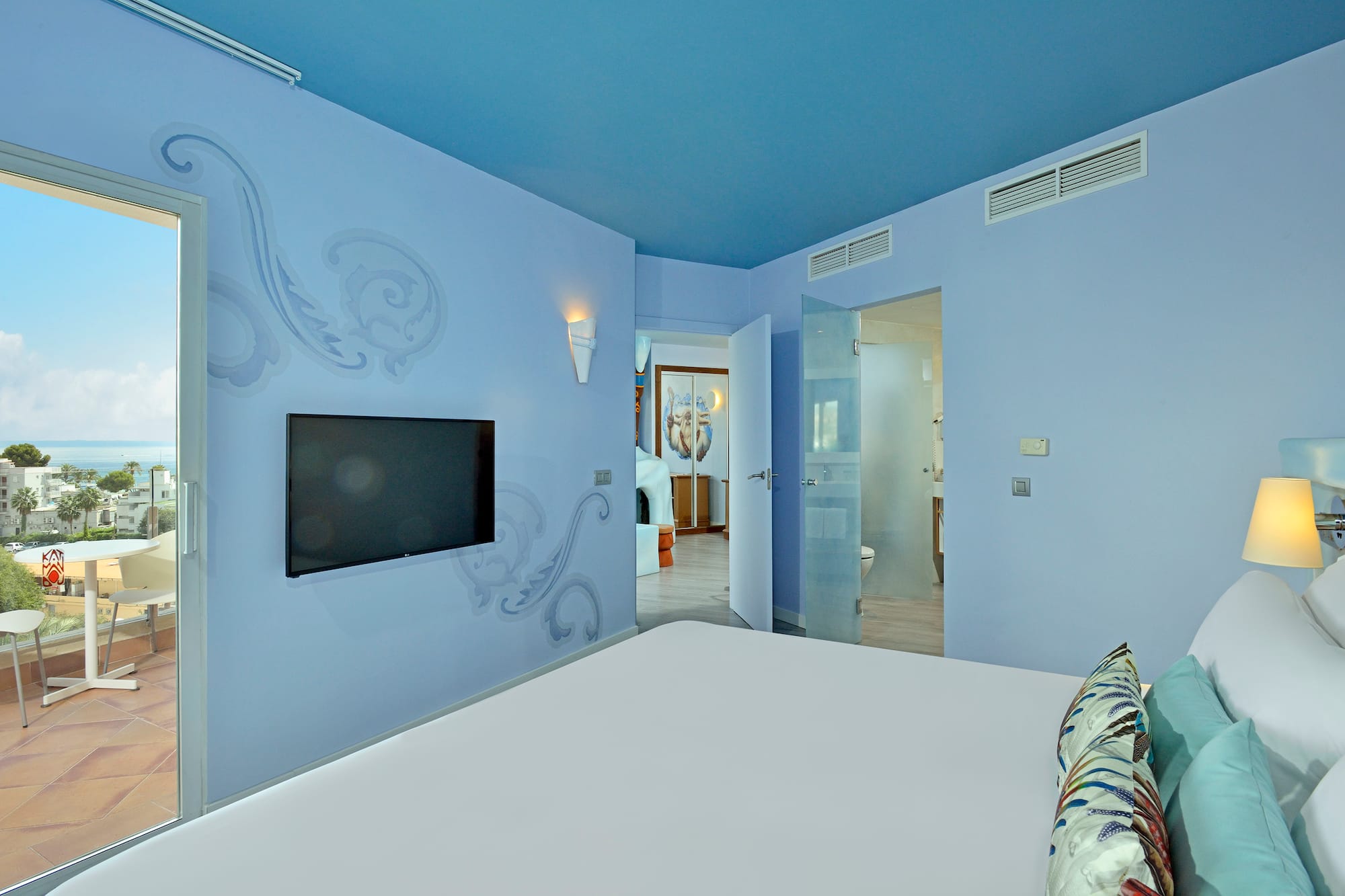 a bedroom with a bed and a television on the wall