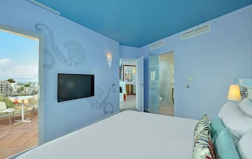 a bedroom with a bed and a television on the wall
