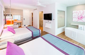 a room with two beds and a tub