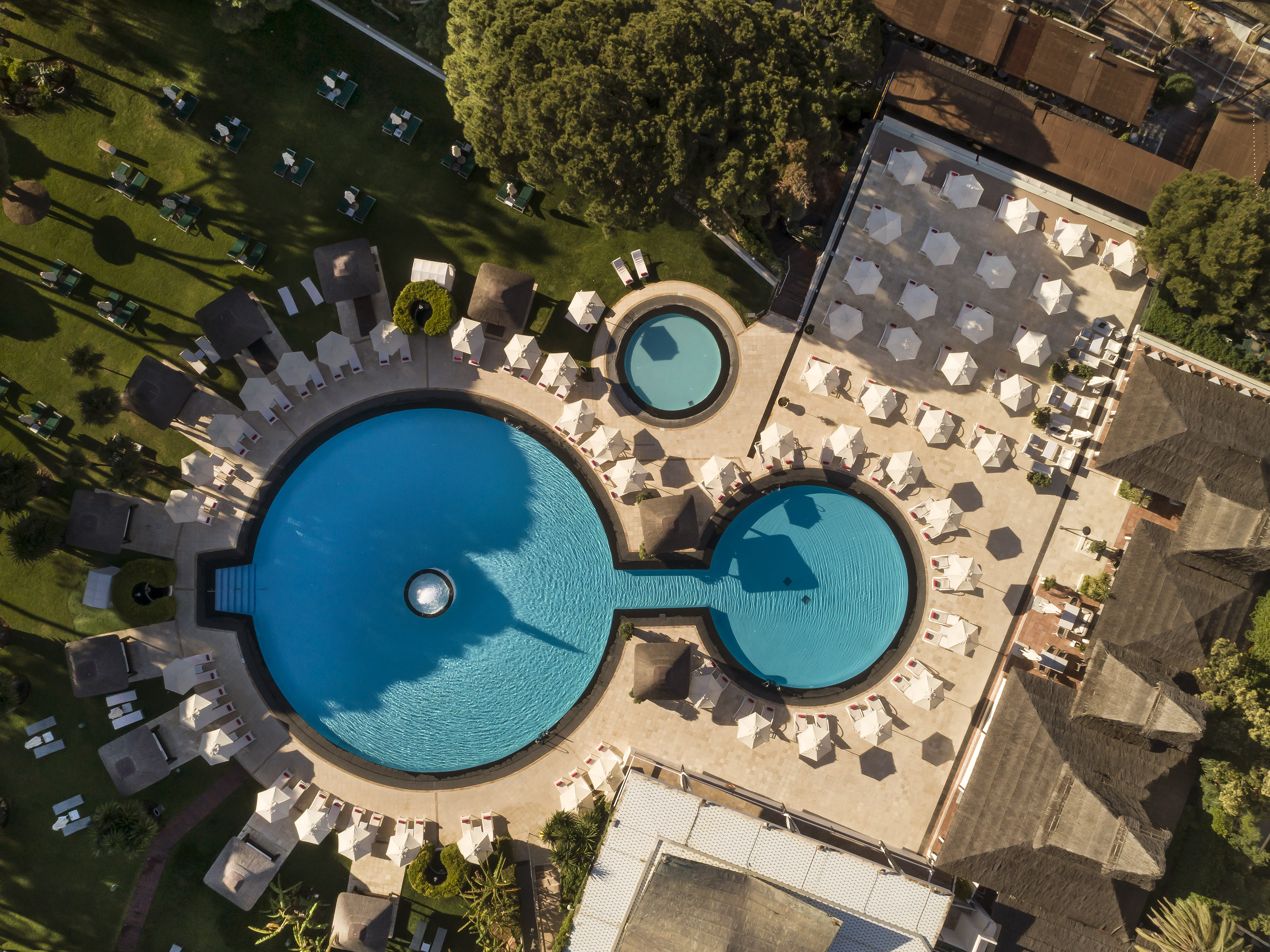 a pool with chairs and umbrellas.