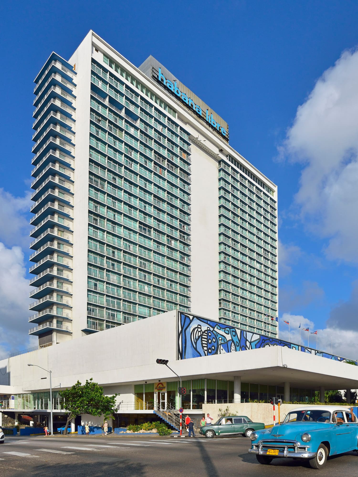 a large building with cars and a blue sky
