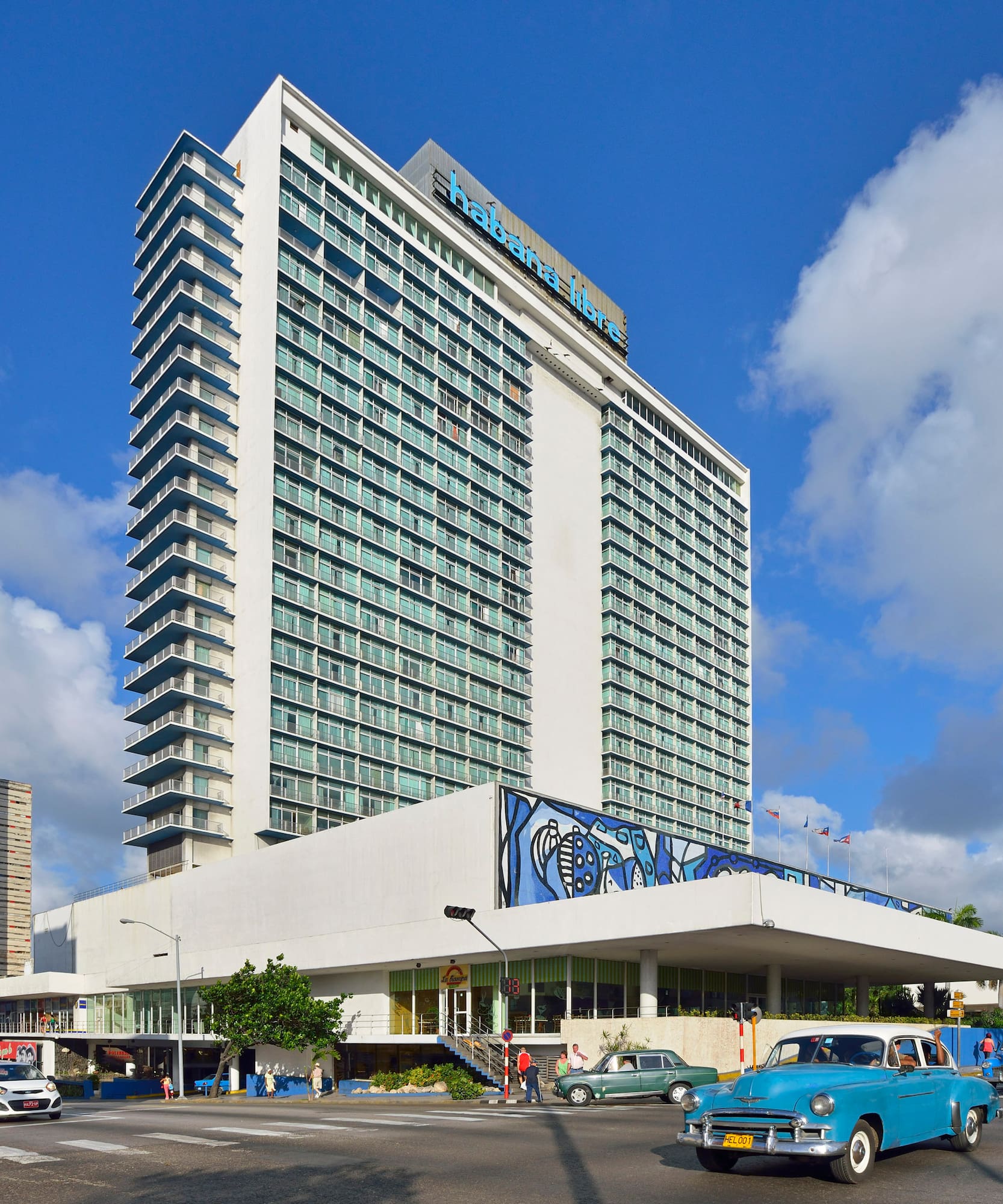 a large building with cars and a blue sky