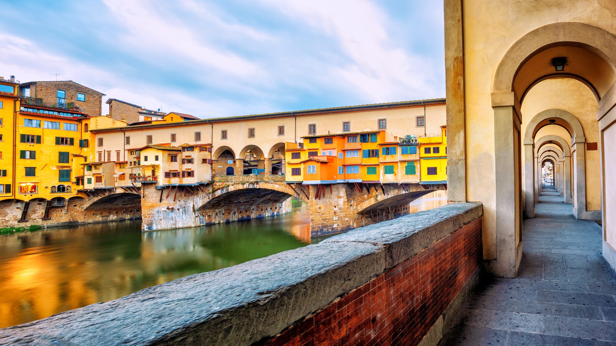 a bridge over water with buildings in the background