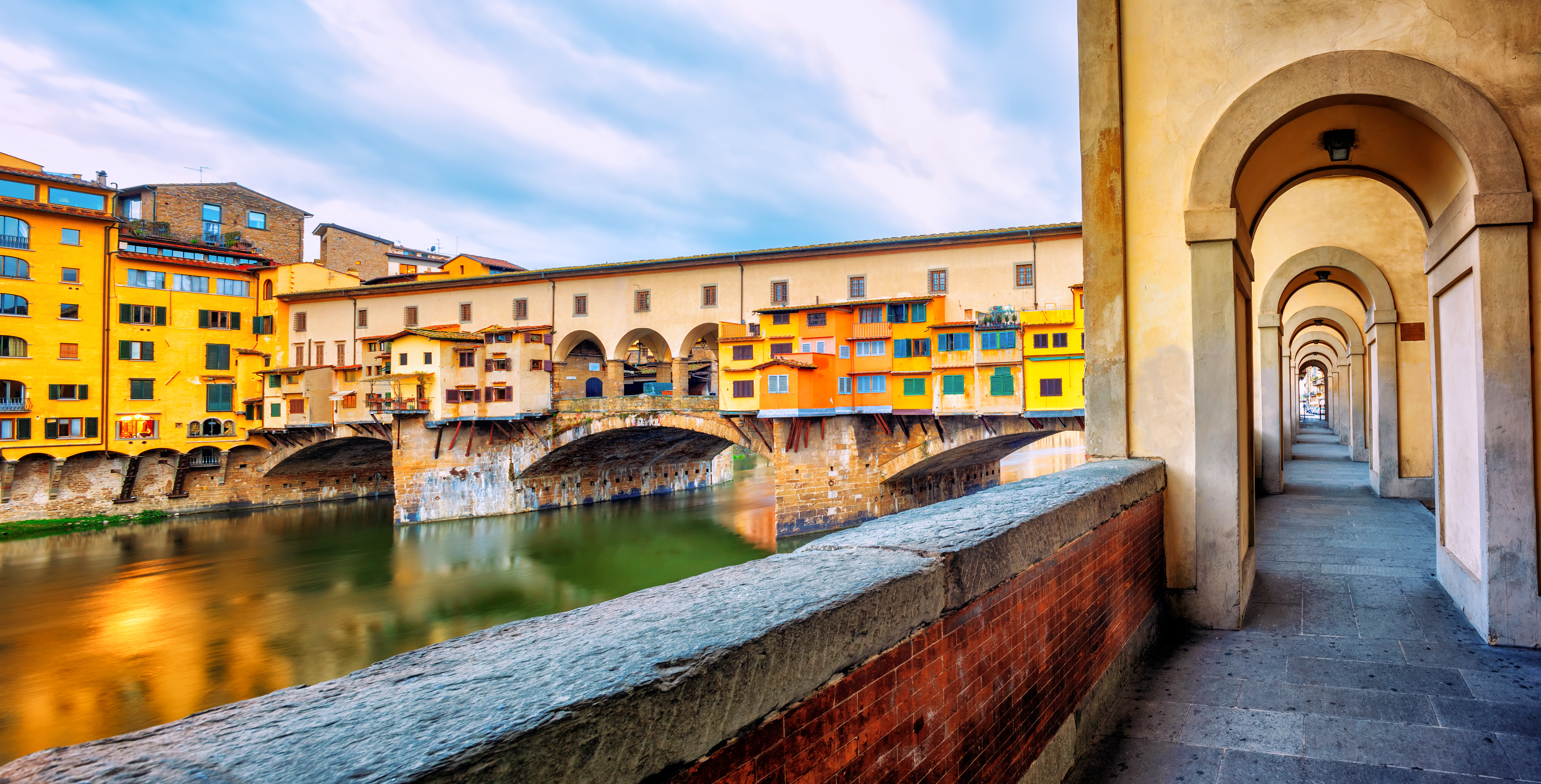 a bridge over water with buildings in the background