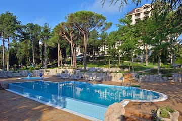 a pool with chairs and trees in the background