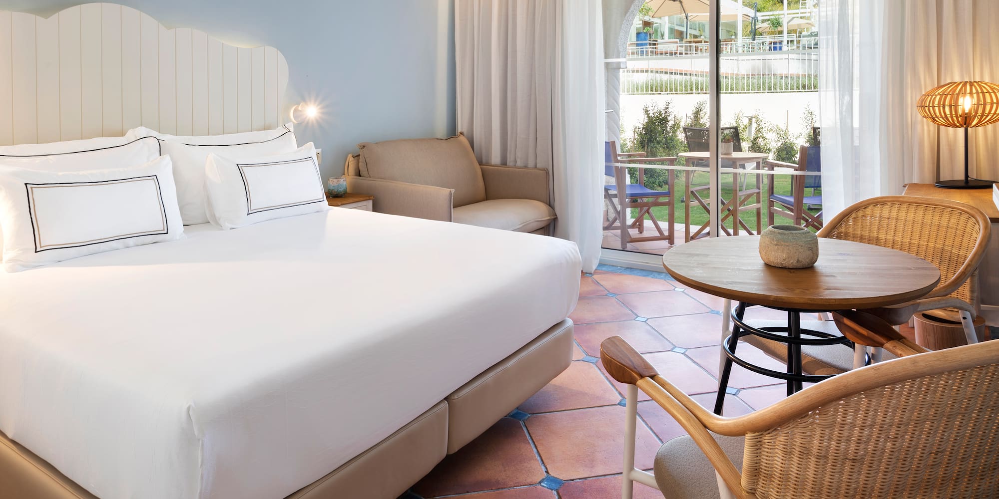 a room with a bed and chairs