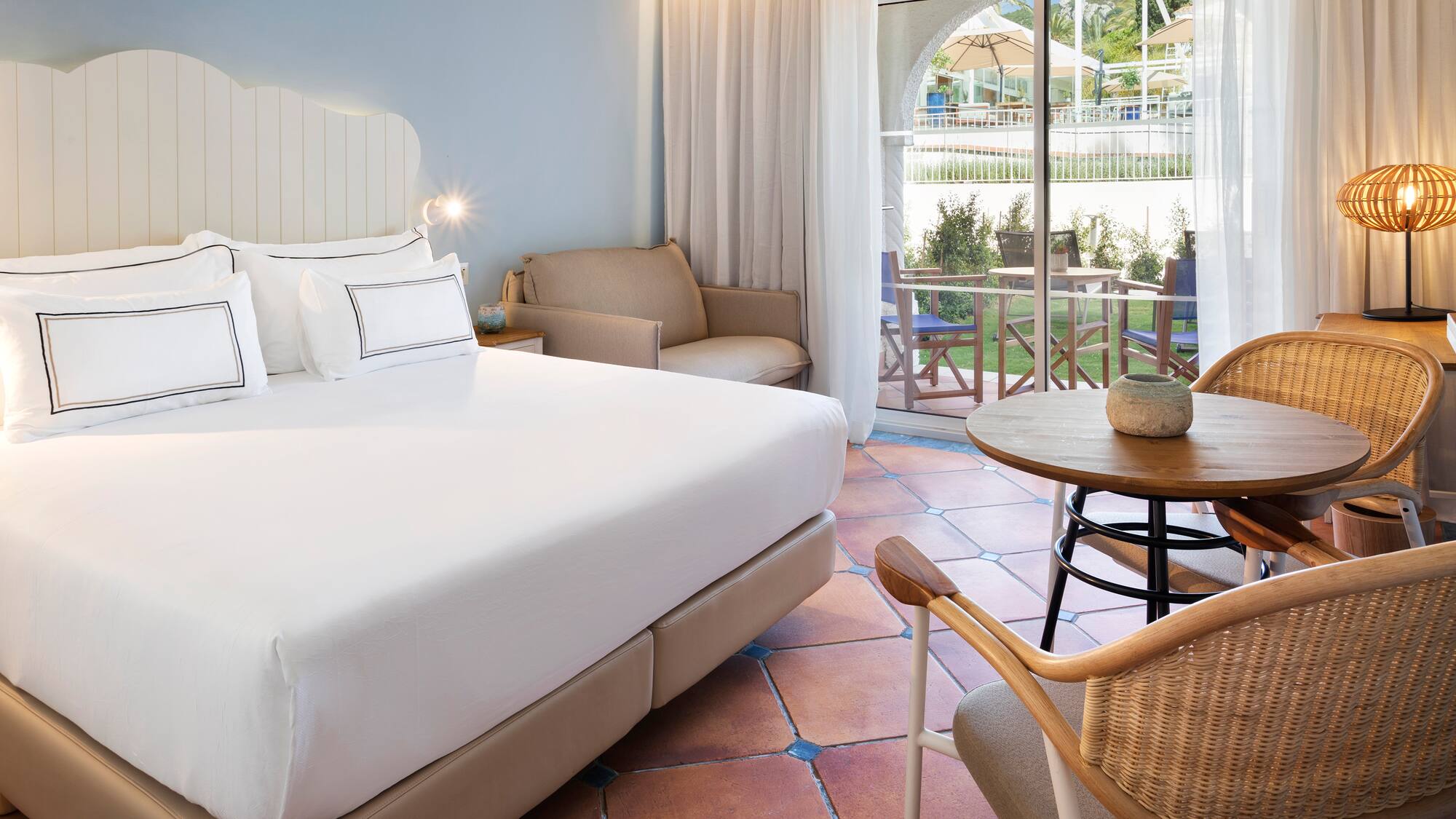 a room with a bed and chairs