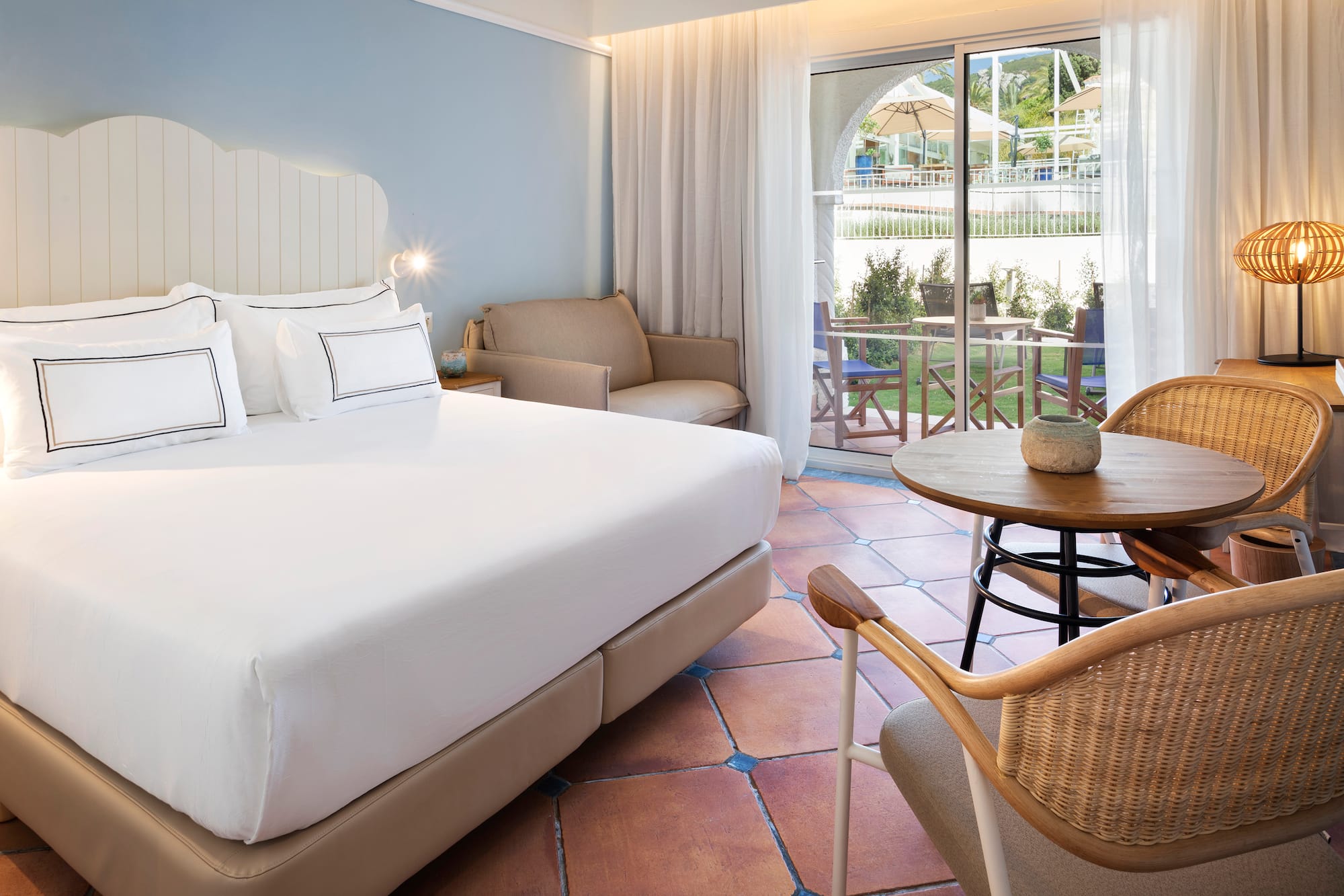 a room with a bed and chairs