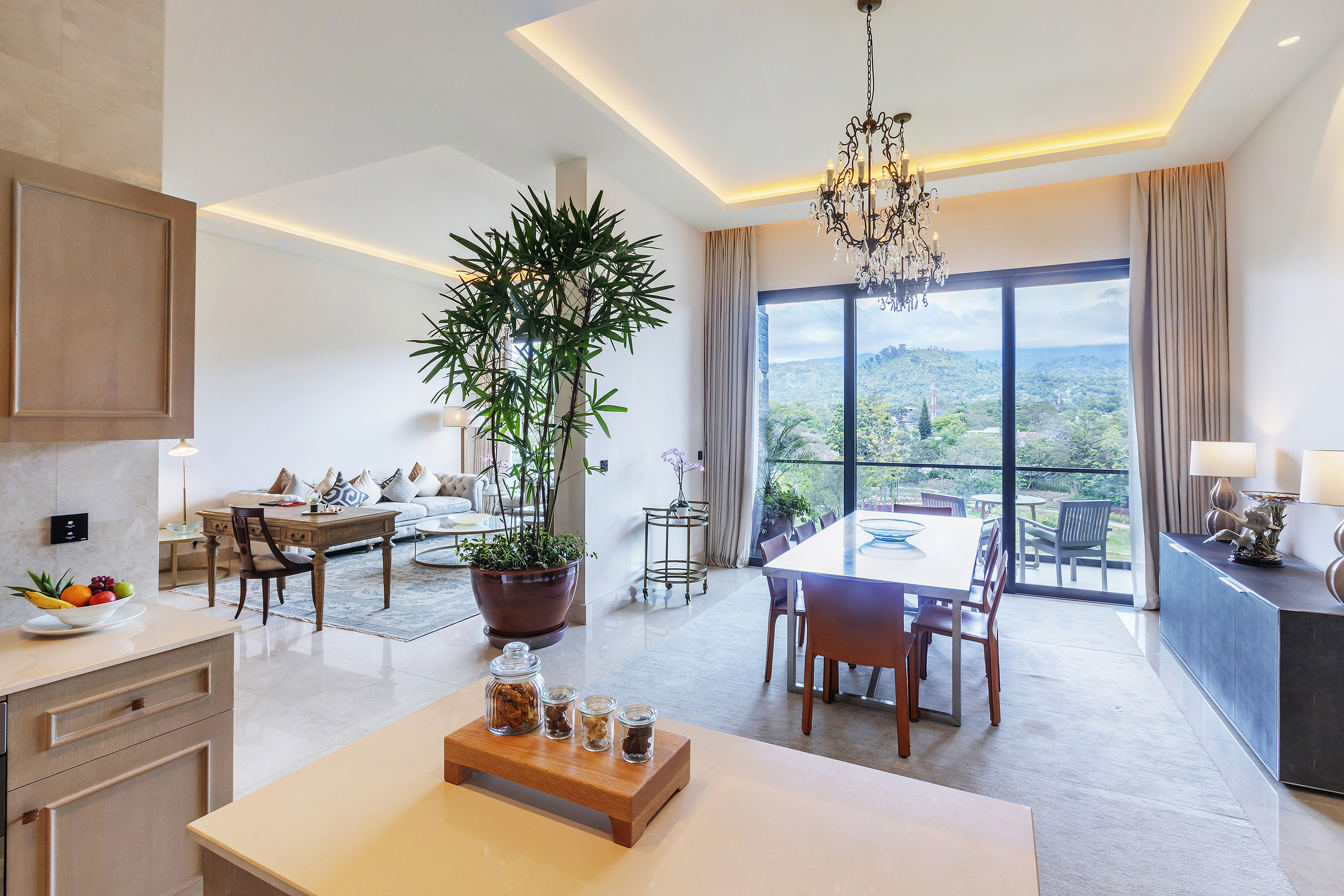 Elegant open plan living, dining, and kitchen with mountain view balcony.