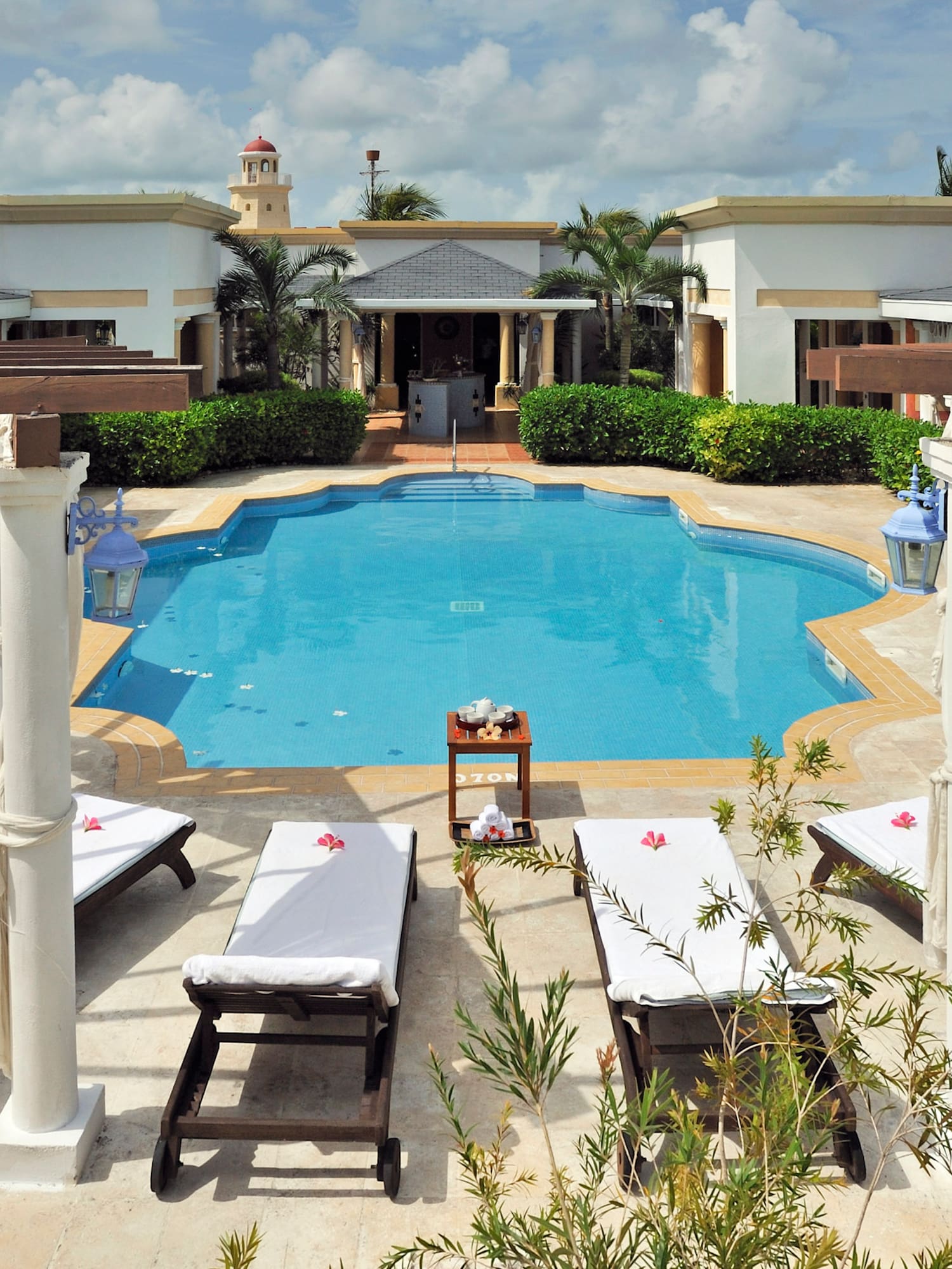 a pool with lounge chairs and a building