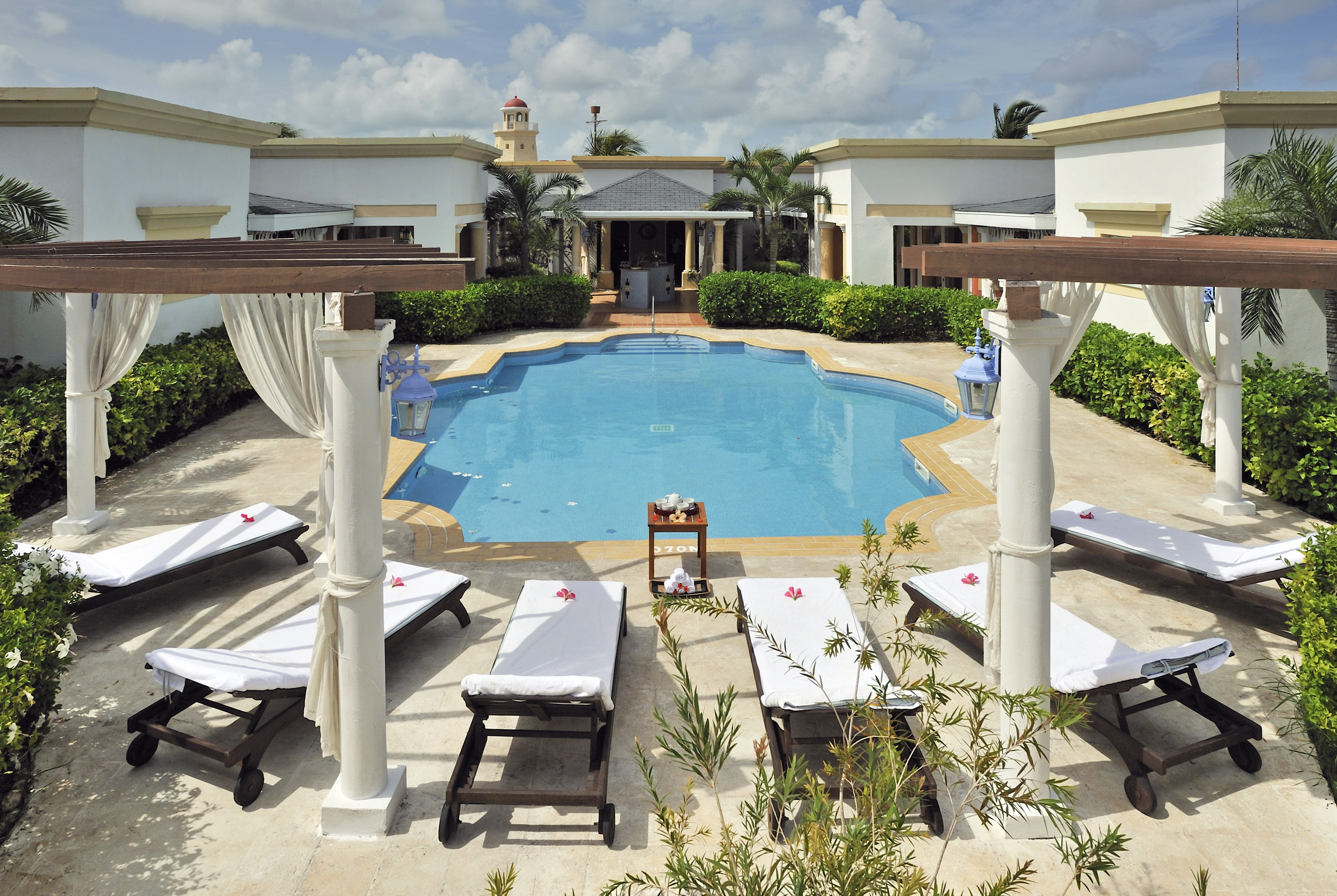 a pool with lounge chairs and a building