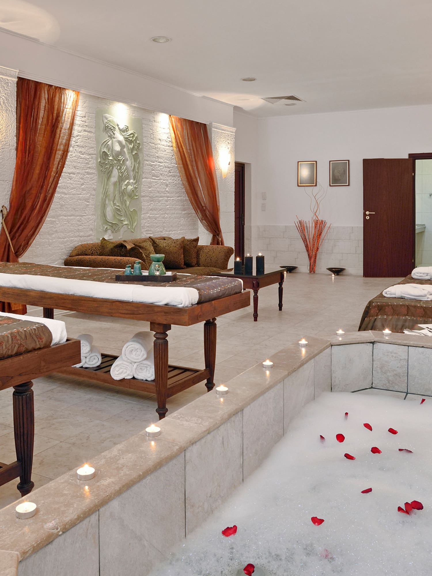 a room with a bathtub and tables