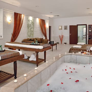a room with a bathtub and tables