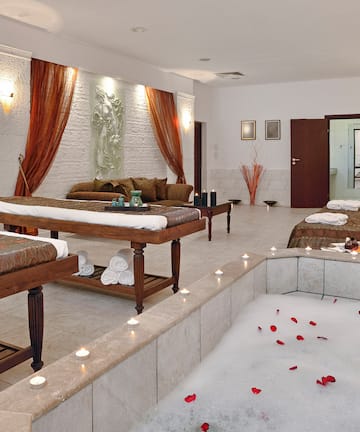 a room with a bathtub and tables